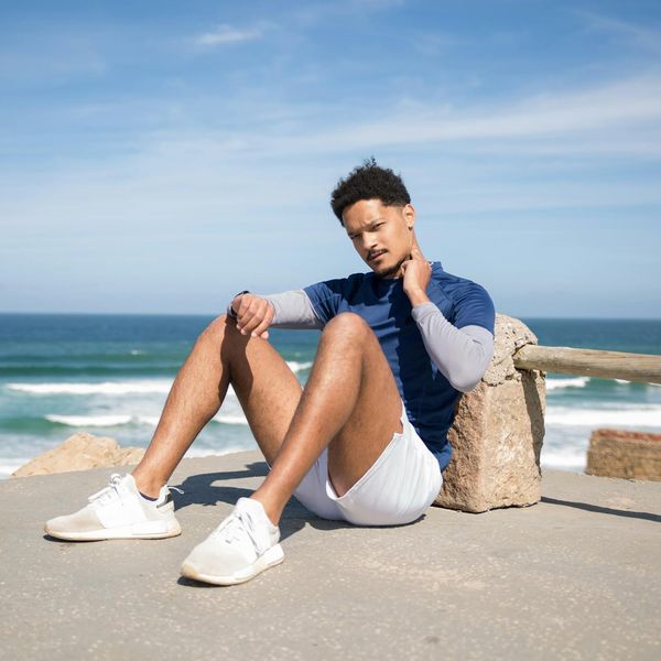 A man stretching outdoors, looking calm and relaxed in a natural setting.